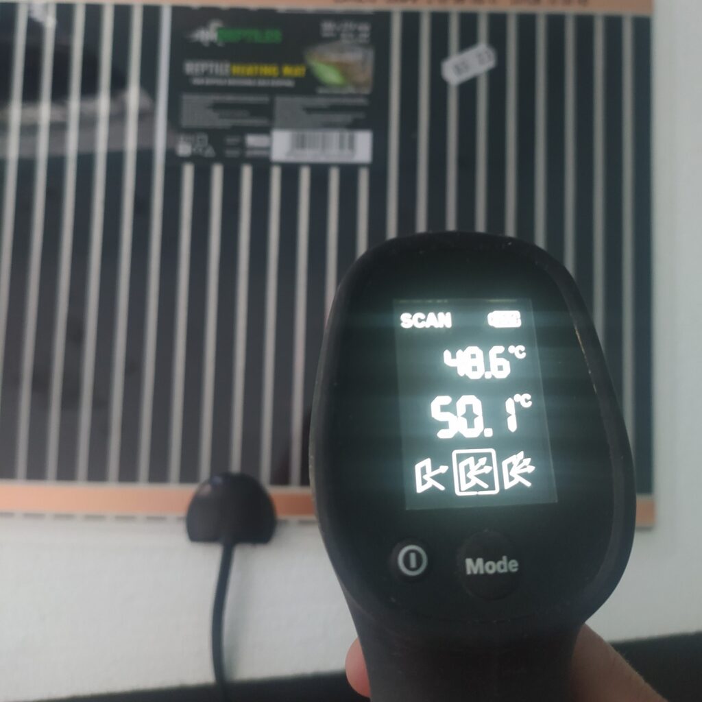 pomiar temperatury maty grzewczej leżącej na styropianie za pomocą termometru